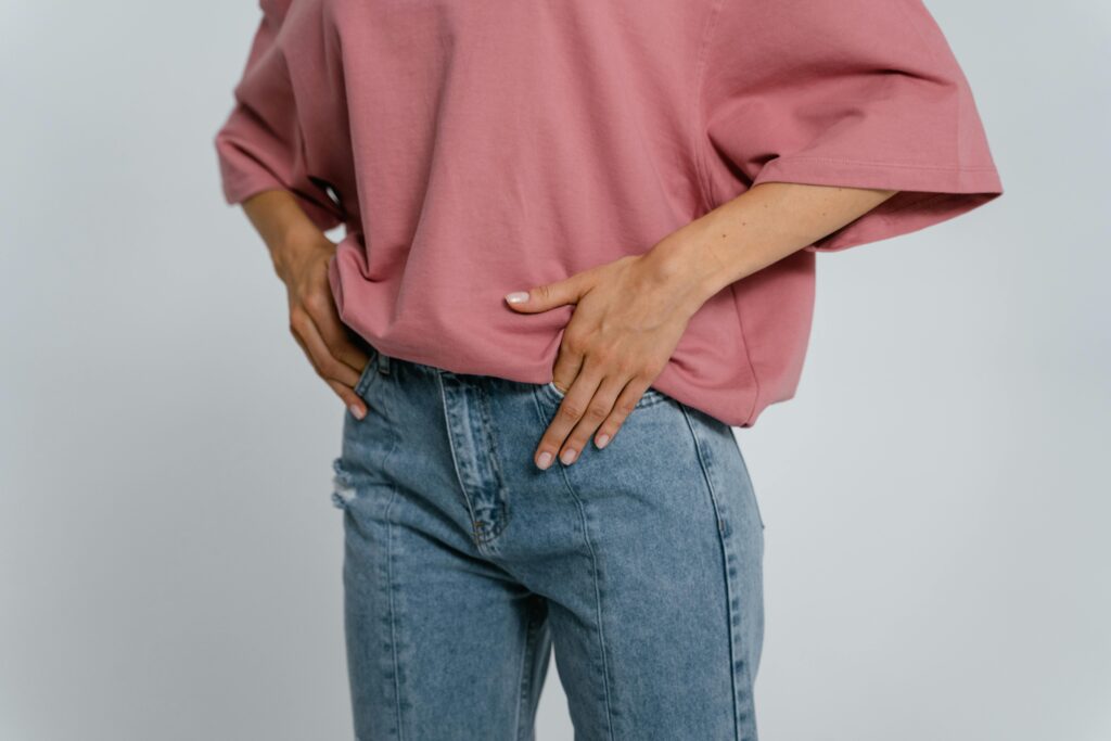 Stylish outfit featuring a pink oversized t-shirt and blue denim jeans in a studio setting.